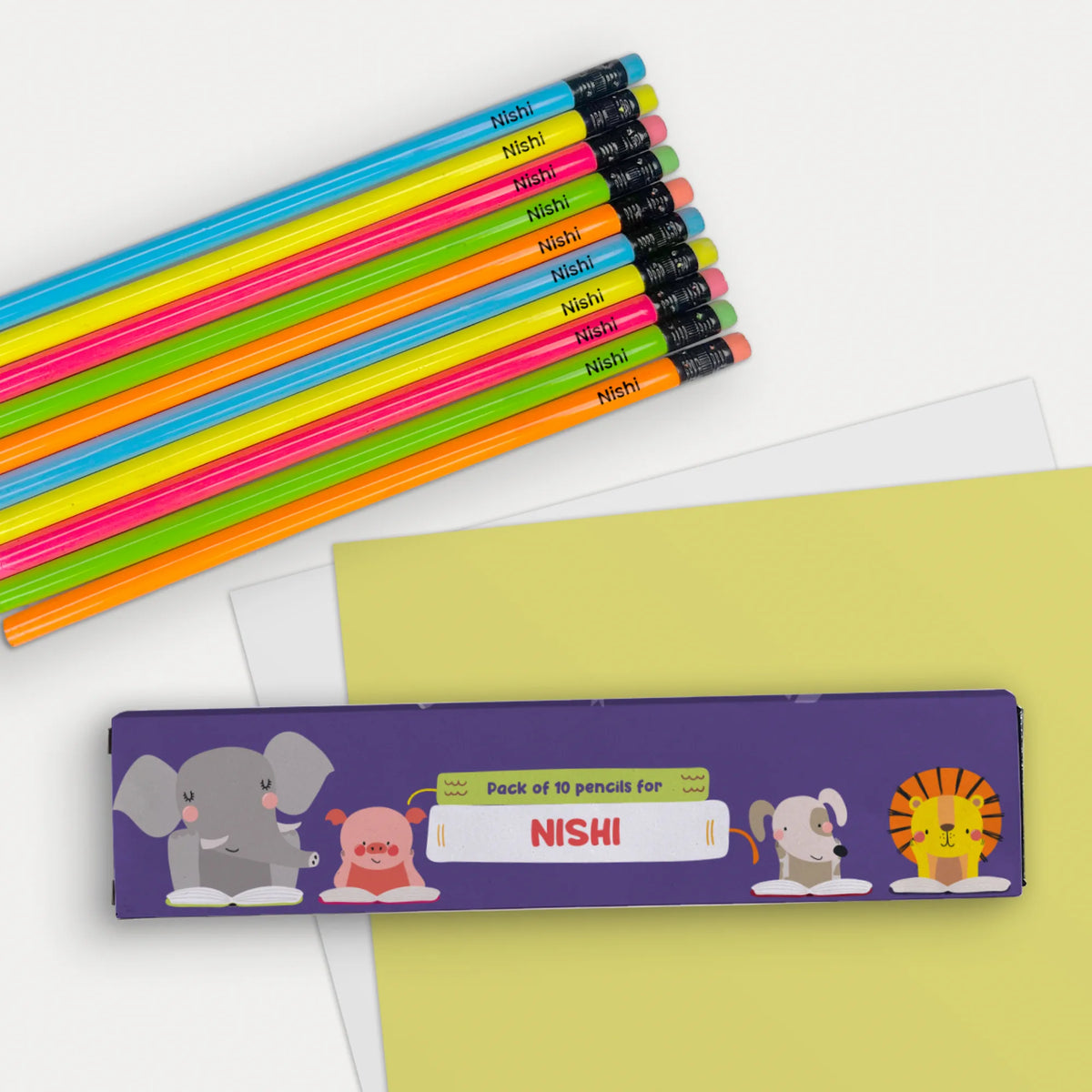 A personalized pack of 10 doms pencils with erasers and silver ferrules. In the foreground, a personalized pencil case with cartoon animal illustrations and the personalized name.