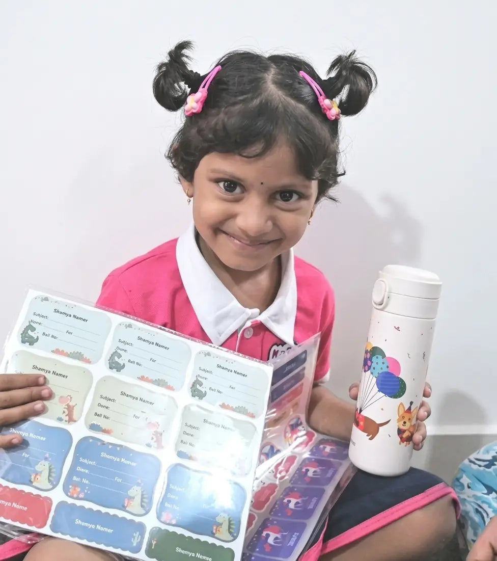 A young girl with pigtails is smiling and holding a personalzied insulated water bottle along with printed sticker sheets.